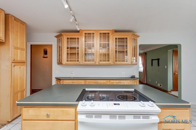 kitchen featuring glass insert cabinets, dark countertops, white electric stove, and light tile patterned floors