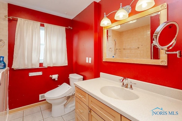 bathroom featuring tile patterned floors, toilet, vanity, baseboards, and walk in shower