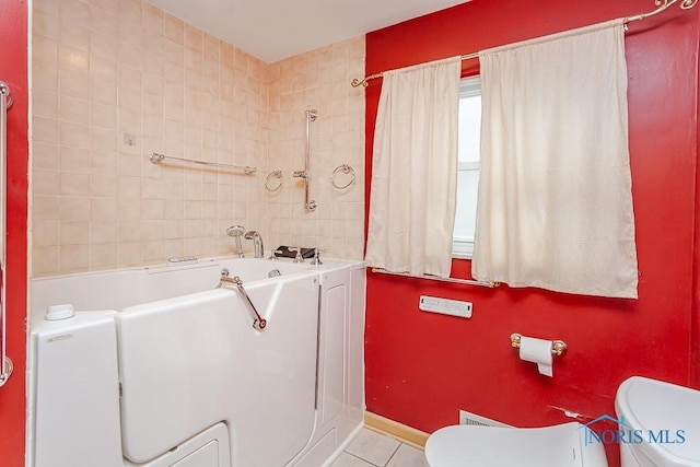 full bath with tile patterned floors, baseboards, toilet, and a bath