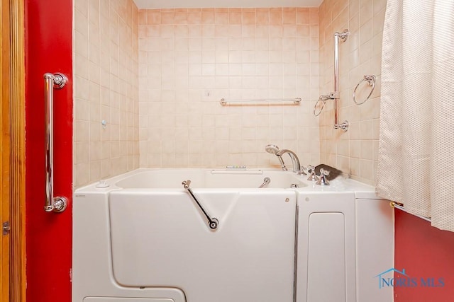 full bathroom with a shower with curtain, a washtub, and tile walls