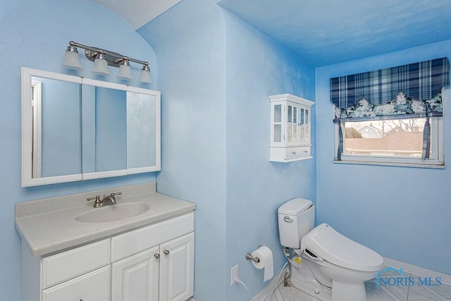 bathroom with toilet, baseboards, and vanity