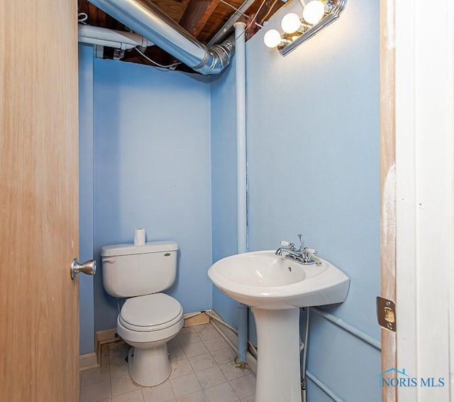 bathroom featuring tile patterned flooring, toilet, and baseboards