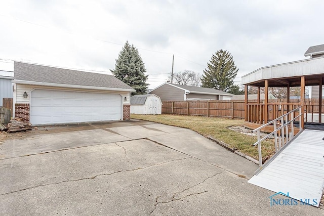 view of yard featuring an outbuilding, fence, and a shed