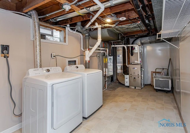 laundry room featuring laundry area, water heater, washing machine and clothes dryer, and heating unit