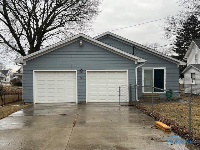 view of front of house featuring a garage, driveway, and fence