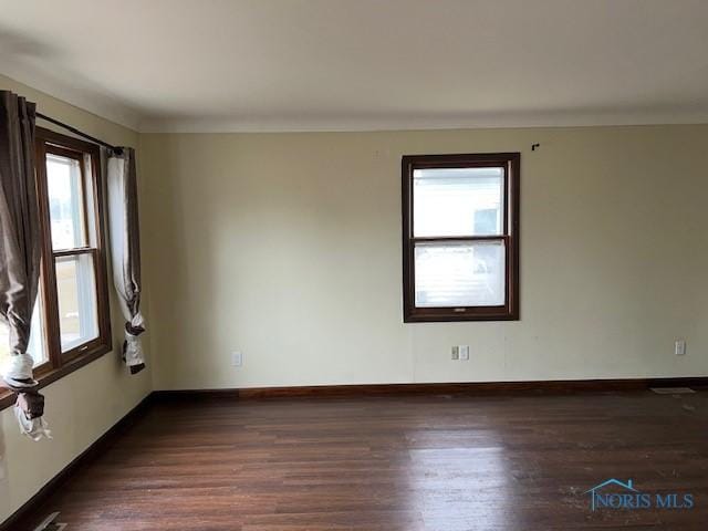 empty room with wood finished floors and baseboards