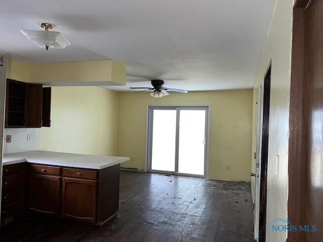 kitchen featuring open shelves, light countertops, open floor plan, ceiling fan, and a peninsula