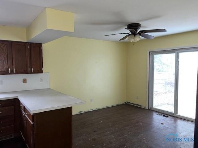 kitchen featuring light countertops, visible vents, ceiling fan, dark brown cabinets, and concrete flooring