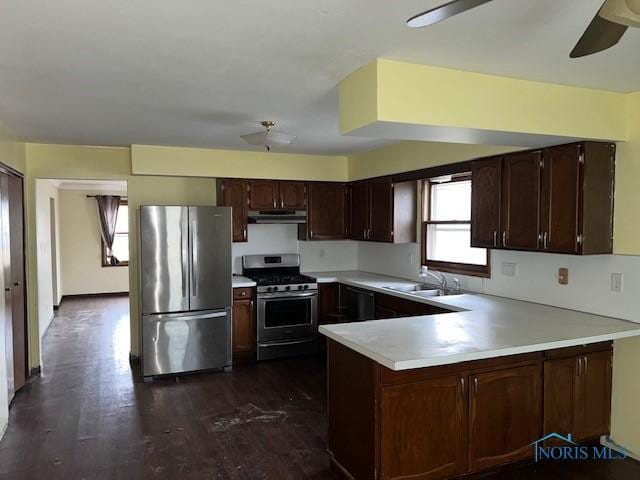 kitchen with ceiling fan, under cabinet range hood, a peninsula, a sink, and appliances with stainless steel finishes