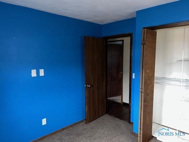 unfurnished bedroom with a closet and carpet flooring