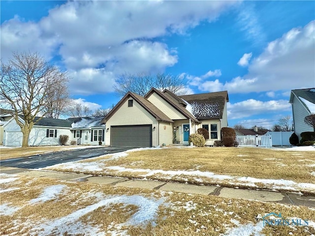 view of front of house with a gate, fence, a garage, and driveway