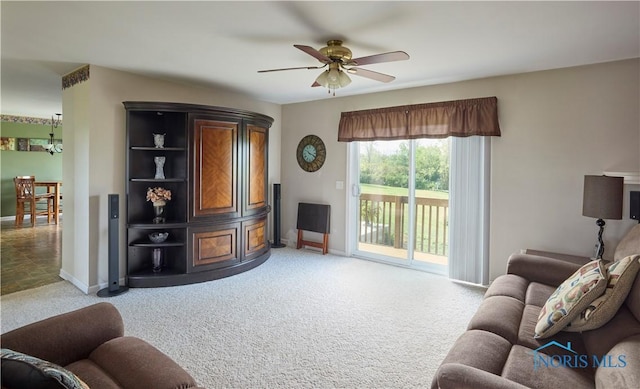 living room with ceiling fan, baseboards, and light colored carpet