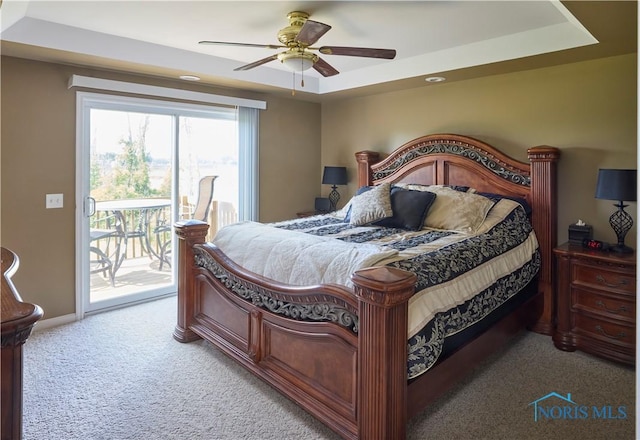 bedroom with light colored carpet, a ceiling fan, baseboards, access to outside, and a raised ceiling