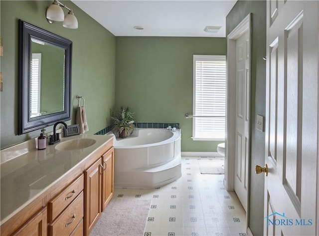 bathroom with visible vents, vanity, toilet, and a bath
