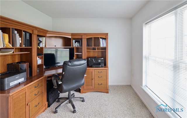 office space featuring light carpet and baseboards