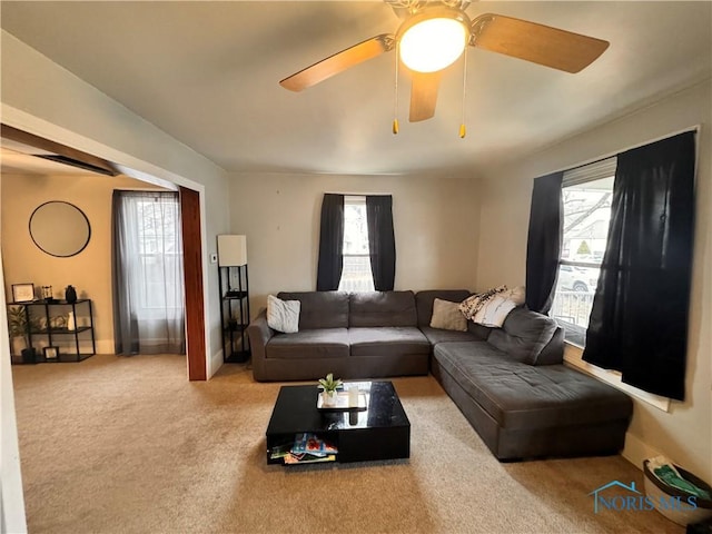 carpeted living area featuring a ceiling fan and baseboards