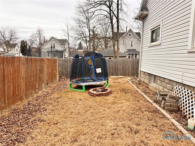 view of yard with a fenced backyard and a trampoline