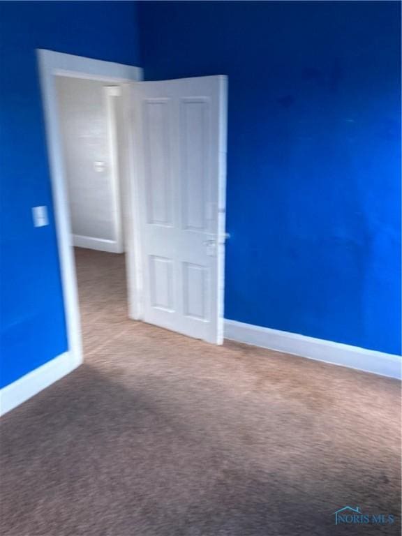 unfurnished bedroom featuring carpet floors and baseboards