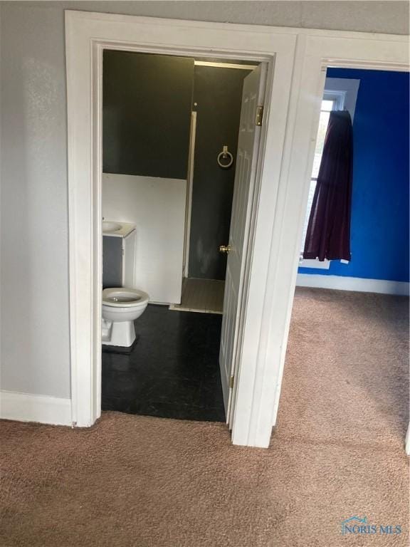 bathroom with toilet, carpet, and baseboards