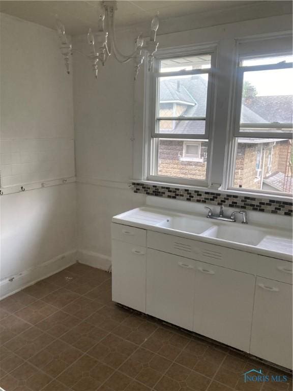 bathroom featuring a sink and backsplash