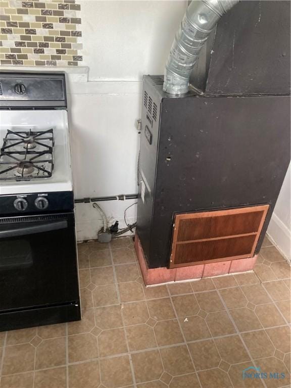 kitchen with tile patterned flooring, range with gas cooktop, and heating unit