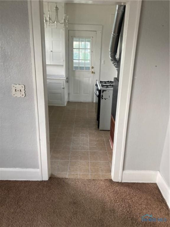 corridor featuring a notable chandelier and light colored carpet