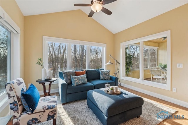 living area featuring lofted ceiling, a ceiling fan, baseboards, and wood finished floors