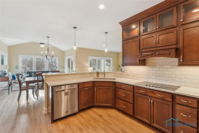 kitchen with a peninsula, black electric stovetop, light countertops, stainless steel dishwasher, and a sink