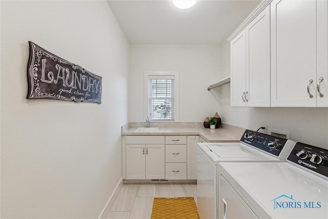 washroom featuring washer and clothes dryer, a sink, cabinet space, and baseboards