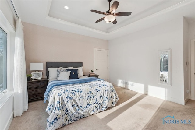 bedroom featuring ceiling fan, carpet, visible vents, and a raised ceiling