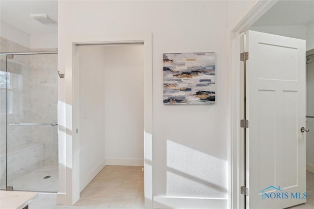 full bathroom featuring a marble finish shower, baseboards, and tile patterned floors