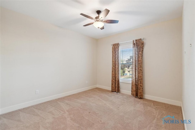 unfurnished room with a ceiling fan, light carpet, and baseboards