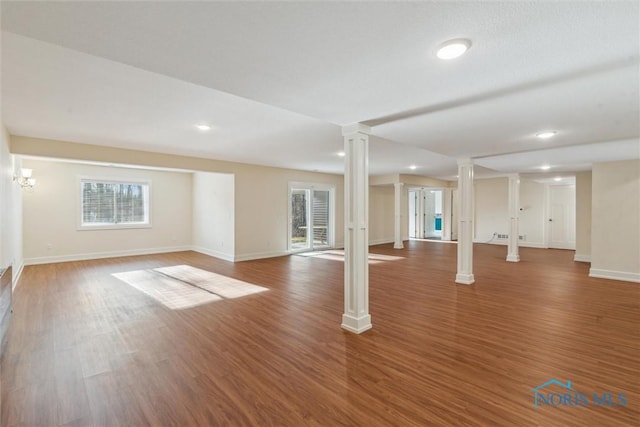 interior space with wood finished floors, decorative columns, and baseboards