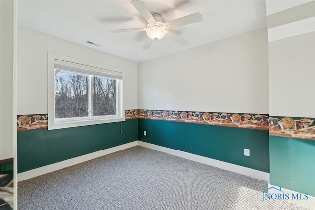 spare room with a ceiling fan, visible vents, and baseboards