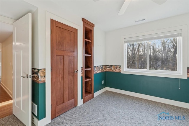 unfurnished room featuring carpet flooring, visible vents, and baseboards