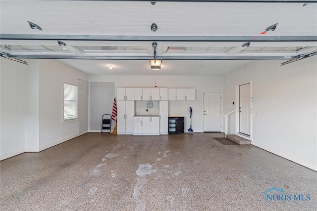 garage featuring a garage door opener and baseboards