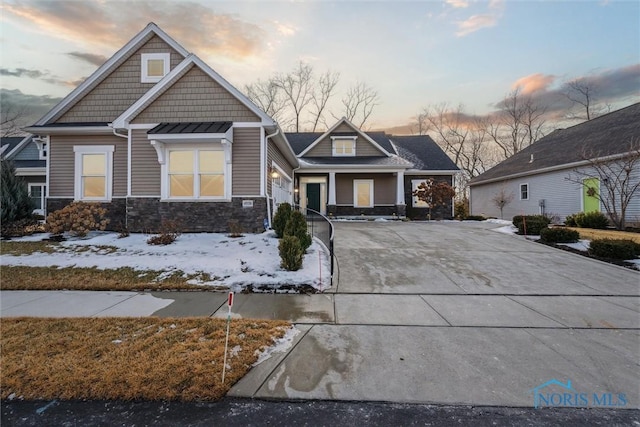 craftsman house with stone siding and concrete driveway