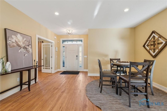 dining space featuring light wood-type flooring, baseboards, and recessed lighting