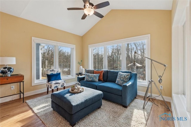 sitting room with light wood-style floors, vaulted ceiling, baseboards, and a ceiling fan