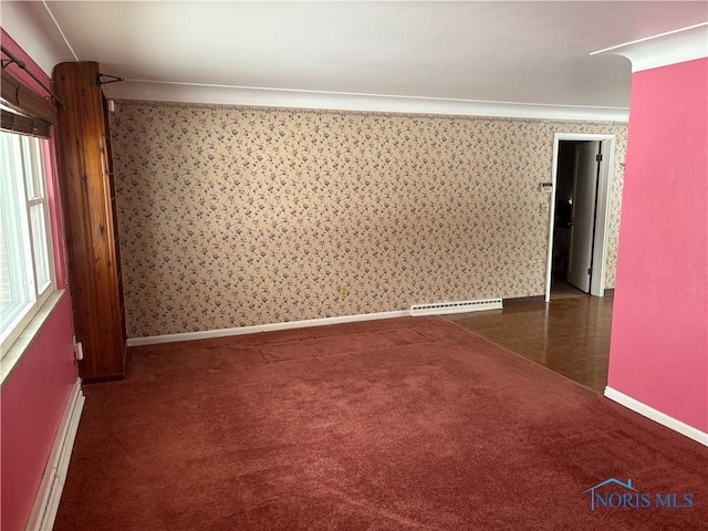 spare room featuring a baseboard heating unit, carpet floors, baseboards, baseboard heating, and wallpapered walls