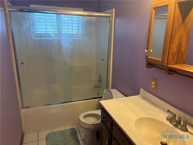 full bathroom with combined bath / shower with glass door, vanity, toilet, and tile patterned floors