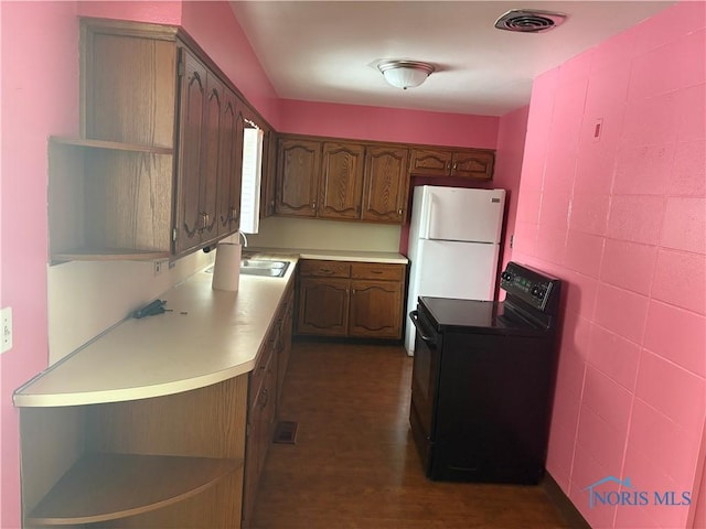 kitchen featuring black range with electric stovetop, a sink, visible vents, freestanding refrigerator, and open shelves