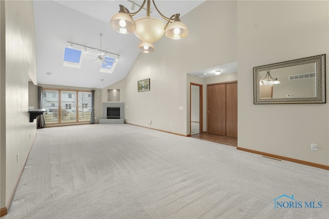 unfurnished living room featuring carpet floors, visible vents, a fireplace with raised hearth, and baseboards