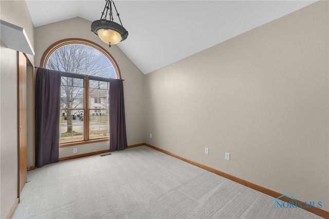 unfurnished room with vaulted ceiling, carpet flooring, visible vents, and baseboards