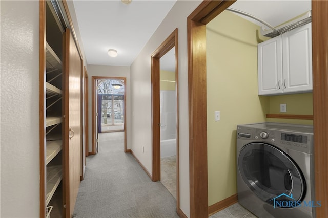 clothes washing area with baseboards, washer / clothes dryer, cabinet space, and light colored carpet