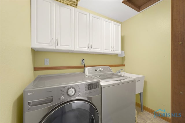 laundry area featuring baseboards, a sink, cabinet space, and washer and dryer