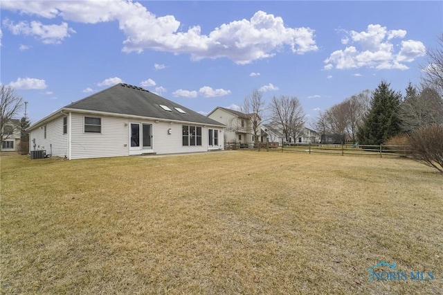 back of house featuring fence, cooling unit, and a yard