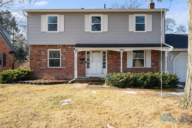 view of front of home featuring brick siding, a front lawn, a chimney, and a garage