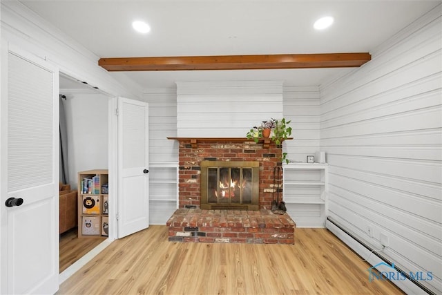 living room with beamed ceiling, baseboard heating, a fireplace, and wood finished floors