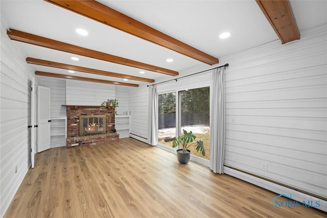 unfurnished living room with a brick fireplace, a baseboard radiator, wood finished floors, and beamed ceiling